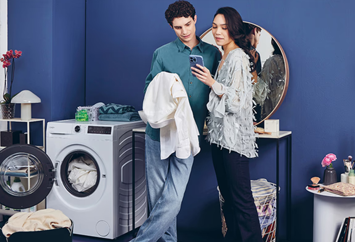 Απεικονίζεται το πλυντήριο σε ένα μπάνιο και ένας άντρας και μια γυναίκα να 